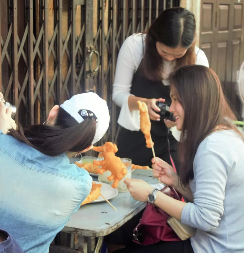 油炸鬼一拿到手，不是急著吃，而是先用手機拍照。