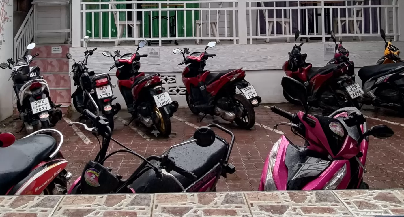 Motorcycles parked outside the hotel, offering rental services.